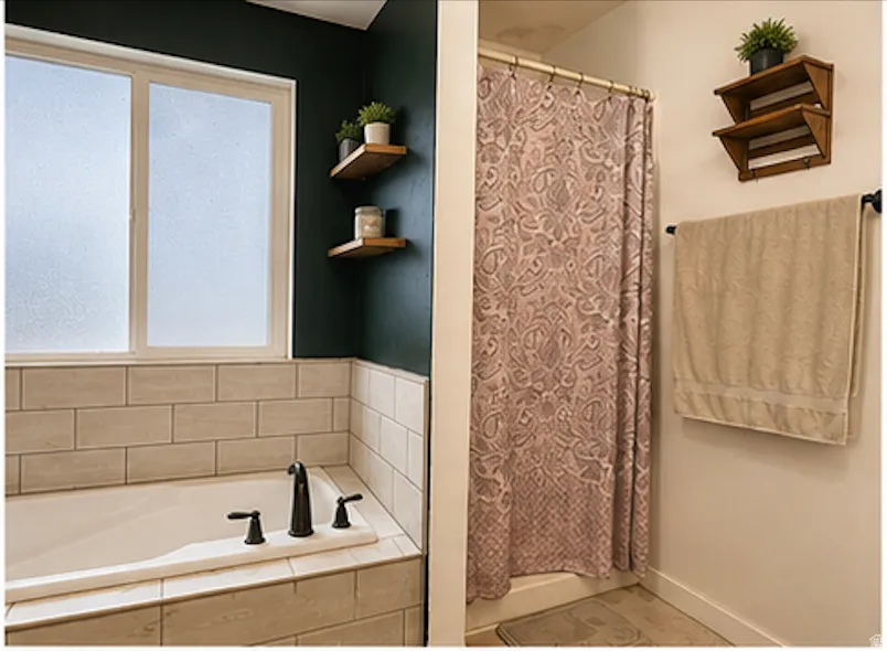Built-in soaking tub with dark bronze fixtures, subway tile surround, and frosted window
