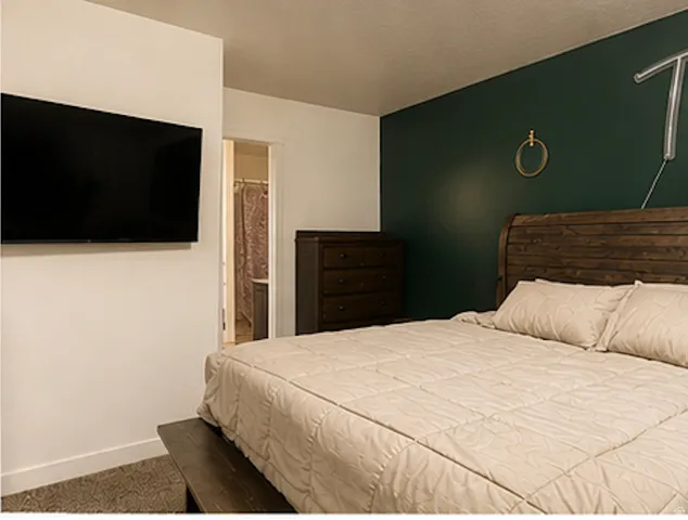 Accent wall with deep green paint and a durable wood-finish bed frame