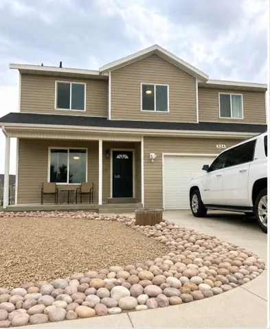 Two-story exterior with light brown siding and white trim