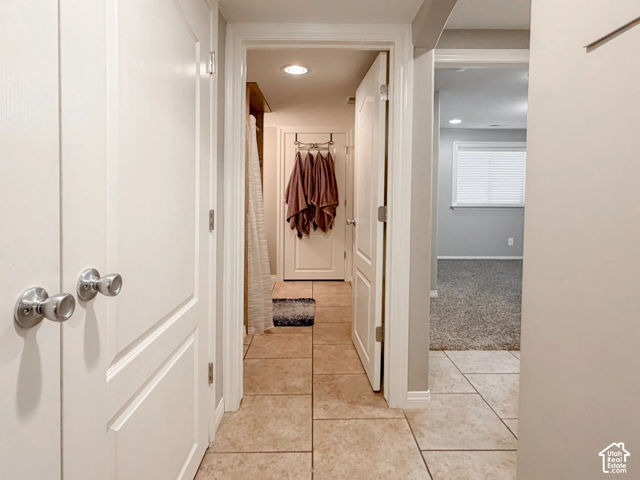 Hallway with large format tile flooring and flush-mounted ceiling lighting