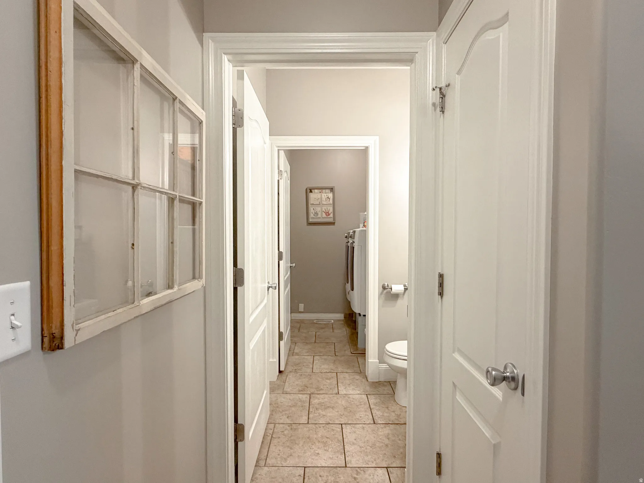 Neutral wall color, white trim, paneled interior doors, and tile flooring