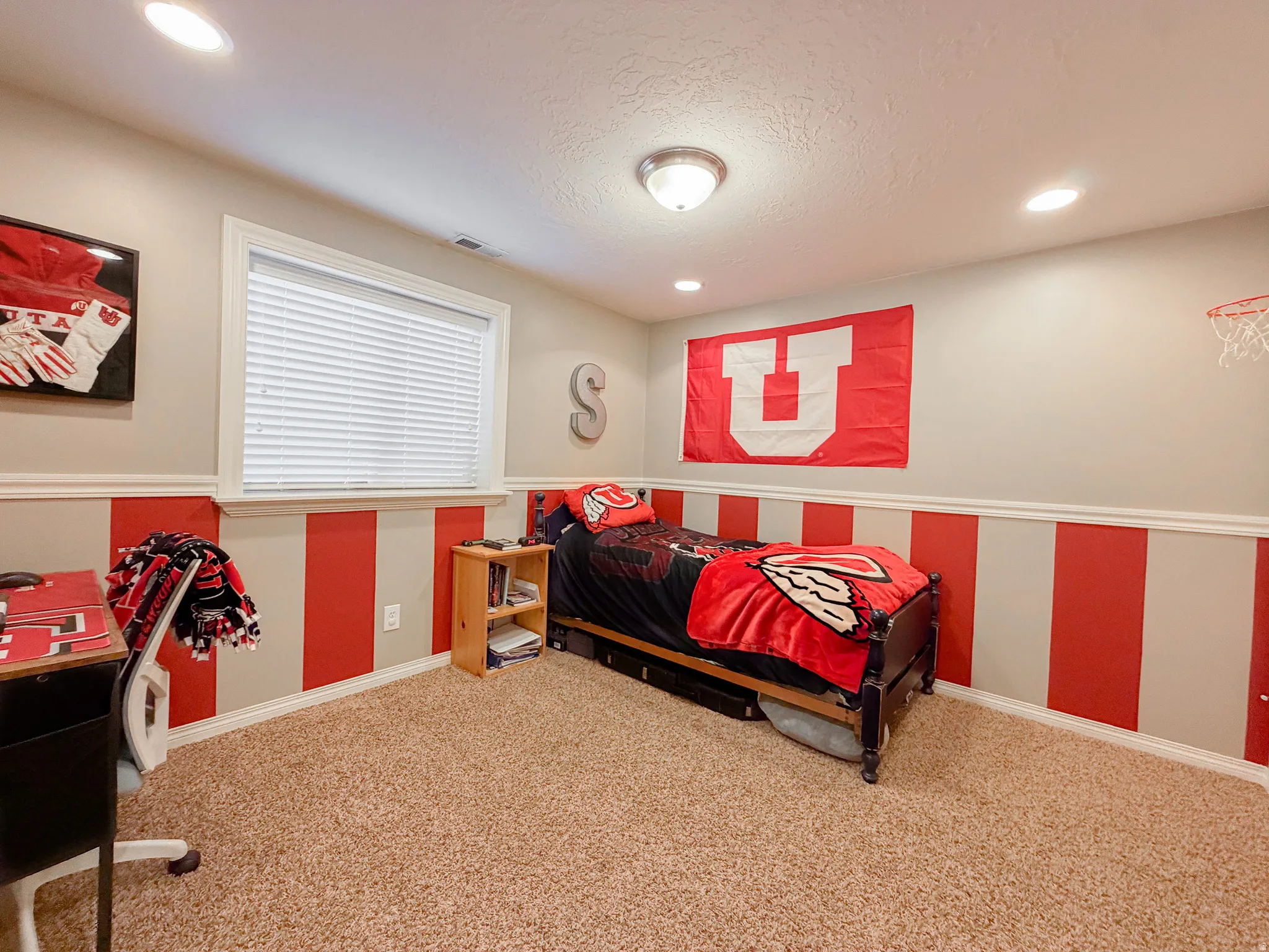 Recessed ceiling lighting, a window with blinds, and textured carpeting