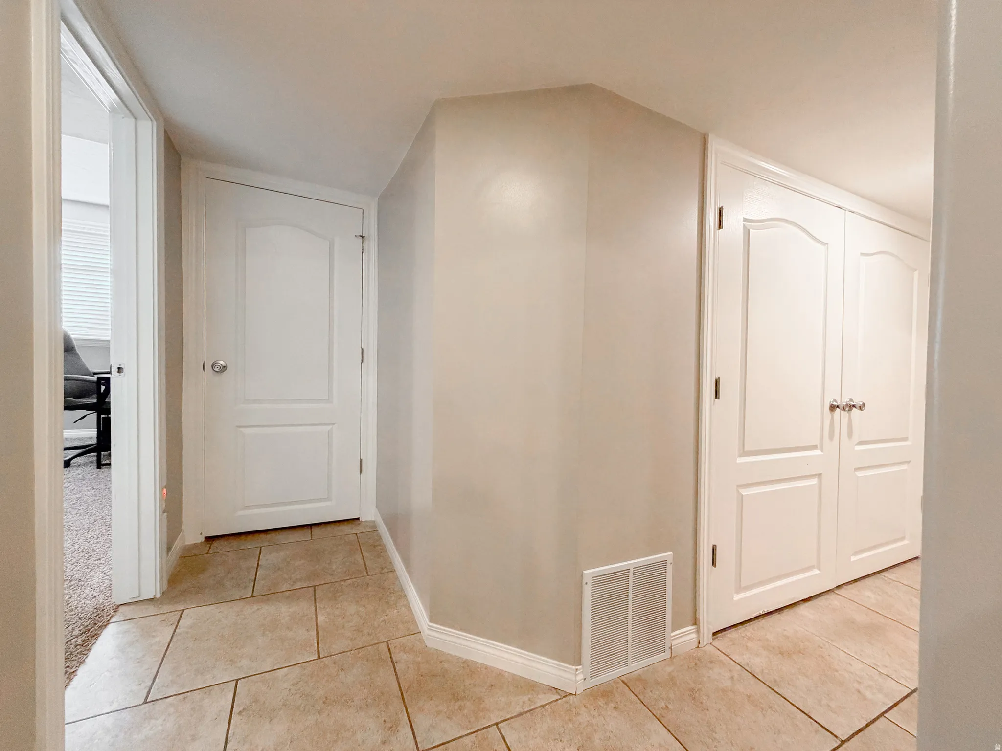 Tiled flooring with a neutral finish, white interior doors, and neutral wall paint