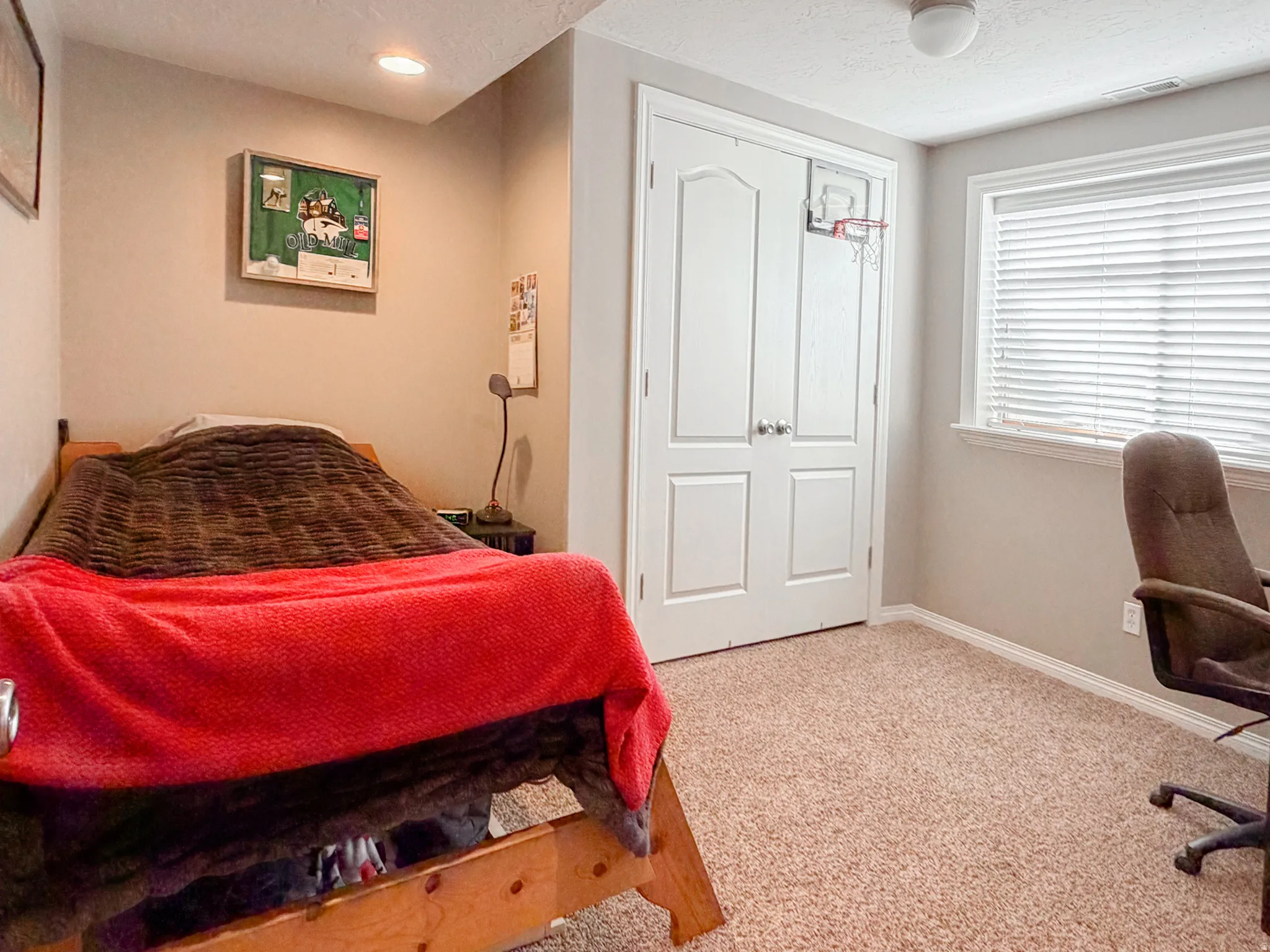 Soft neutral carpeting, white window blinds, and recessed lighting