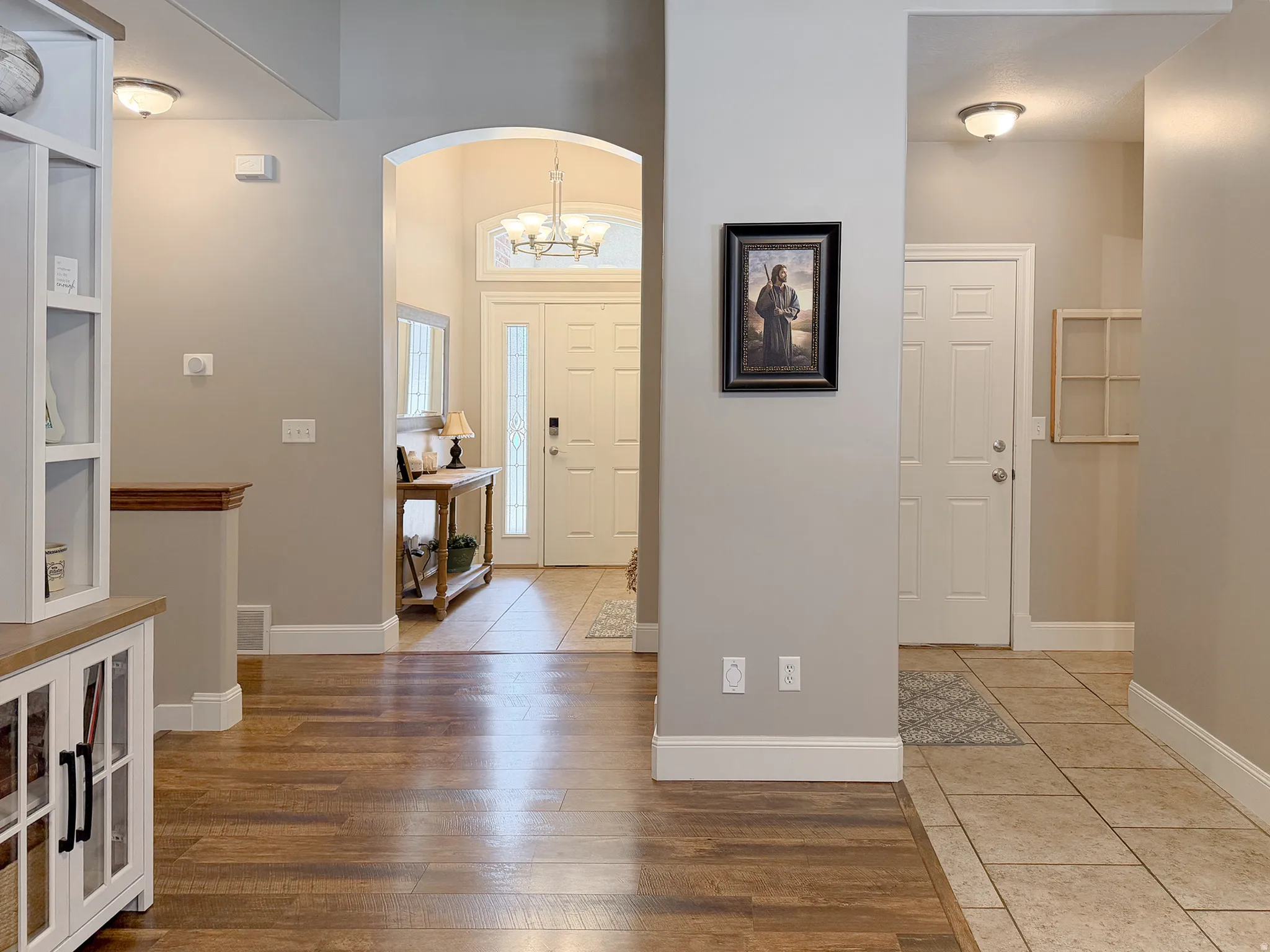 Archway entry with a decorative chandelier