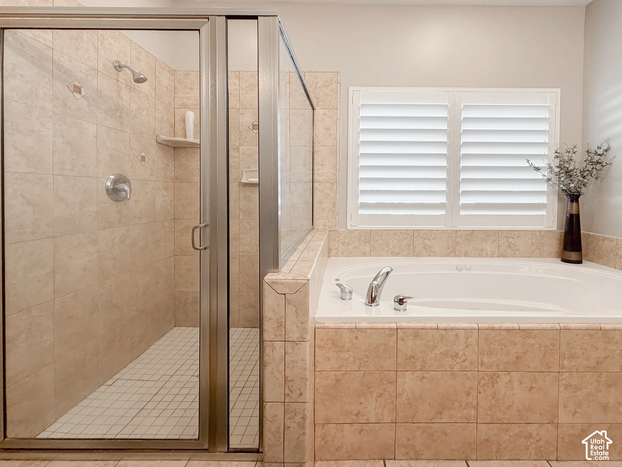 Walk-in shower with clear glass enclosure and tile surround