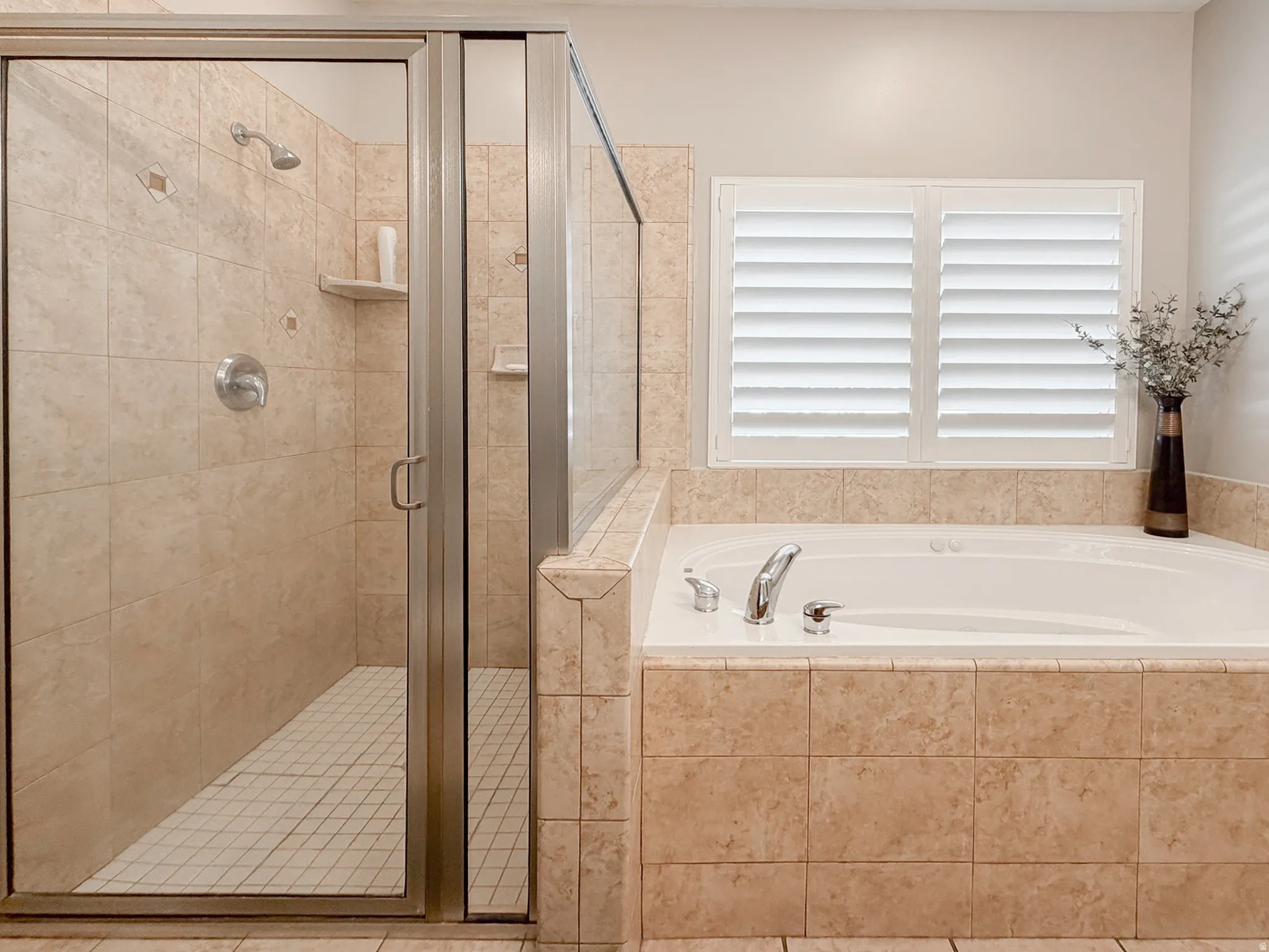Walk-in shower with clear glass enclosure and tile surround