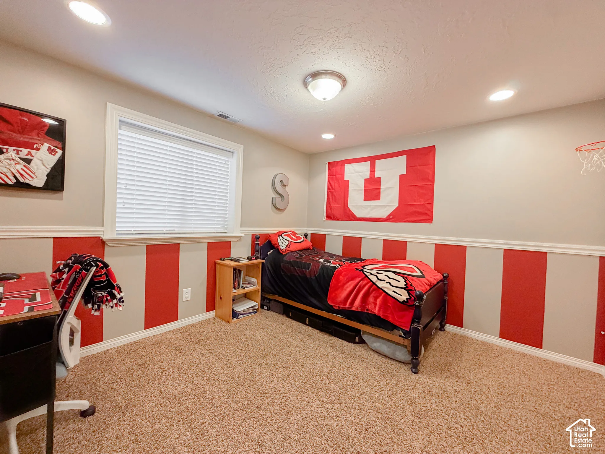 Recessed ceiling lighting, a window with blinds, and textured carpeting