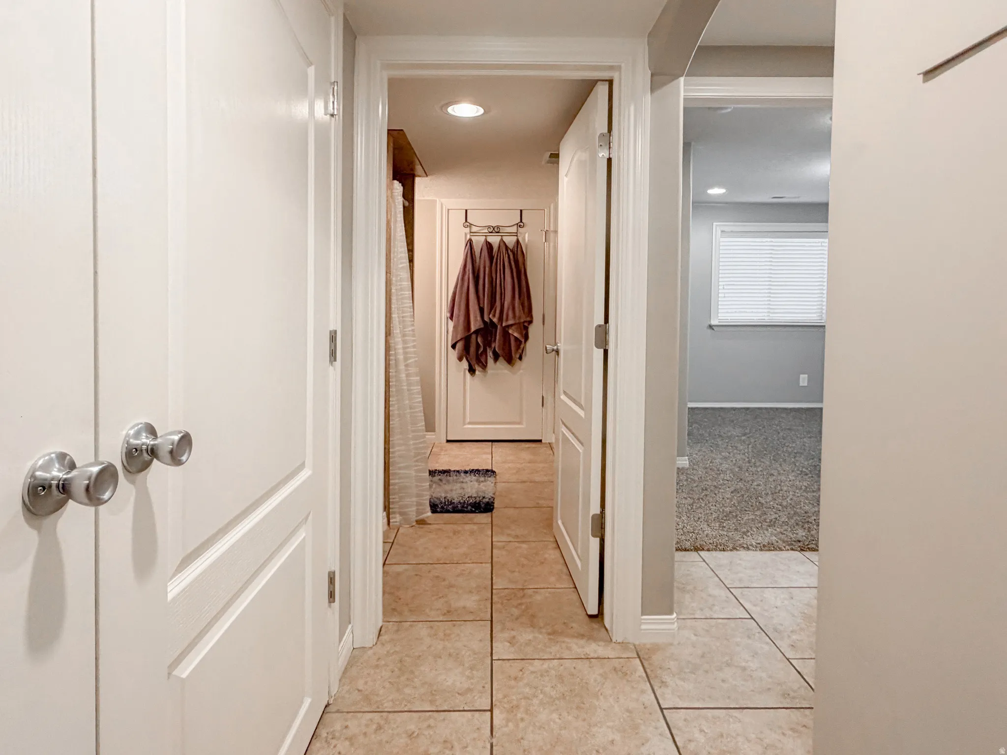Hallway with large format tile flooring and flush-mounted ceiling lighting
