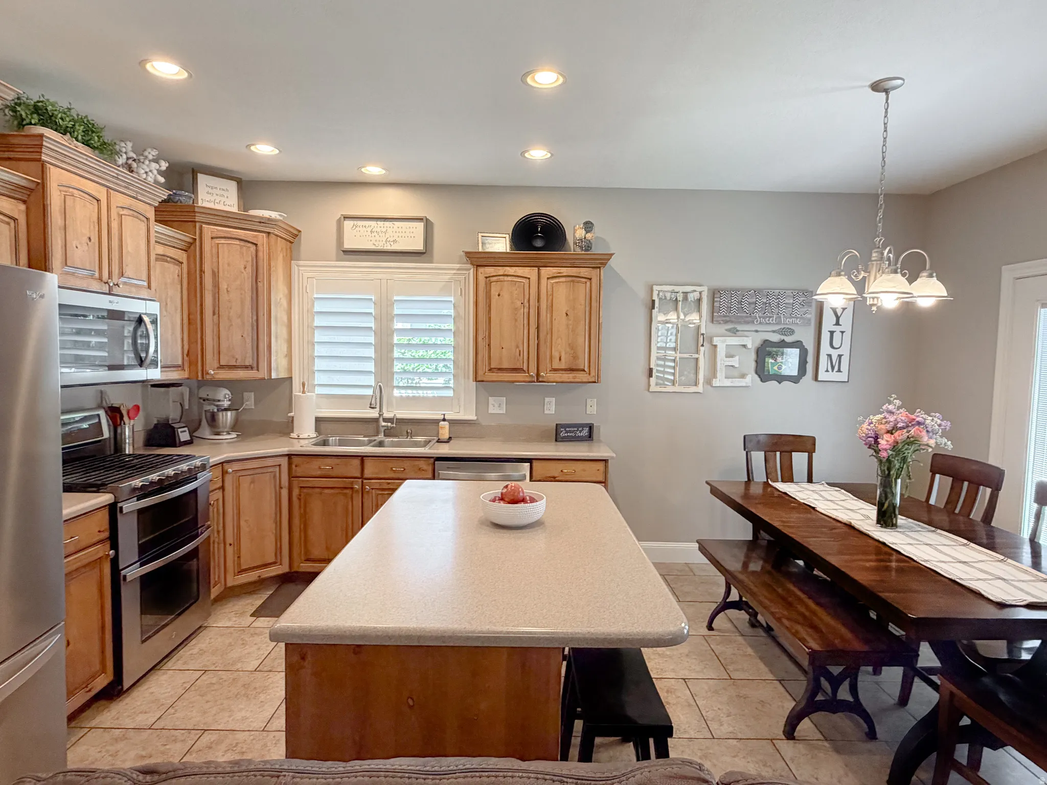 Kitchen with wood cabinetry, stainless steel appliances, recessed lighting, and a center island