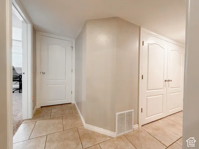 Tiled flooring with a neutral finish, white interior doors, and neutral wall paint
