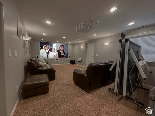 Recessed lighting, wall-mounted sconces, projector, and screen offer an entertainment-ready space
