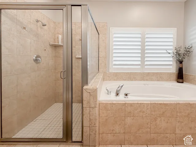Walk-in shower with clear glass enclosure and tile surround