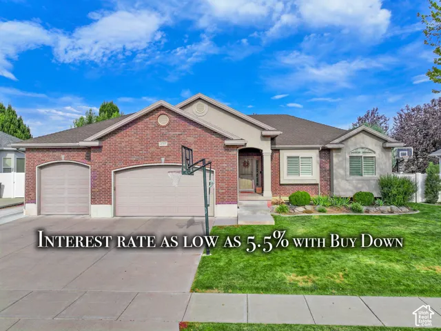 Single-story brick exterior featuring an attached three-car garage, arched entry, and manicured front lawn