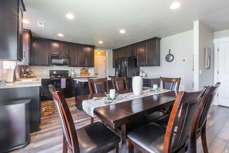 Kitchen with dark wood cabinetry, light-toned countertops, and integrated appliances