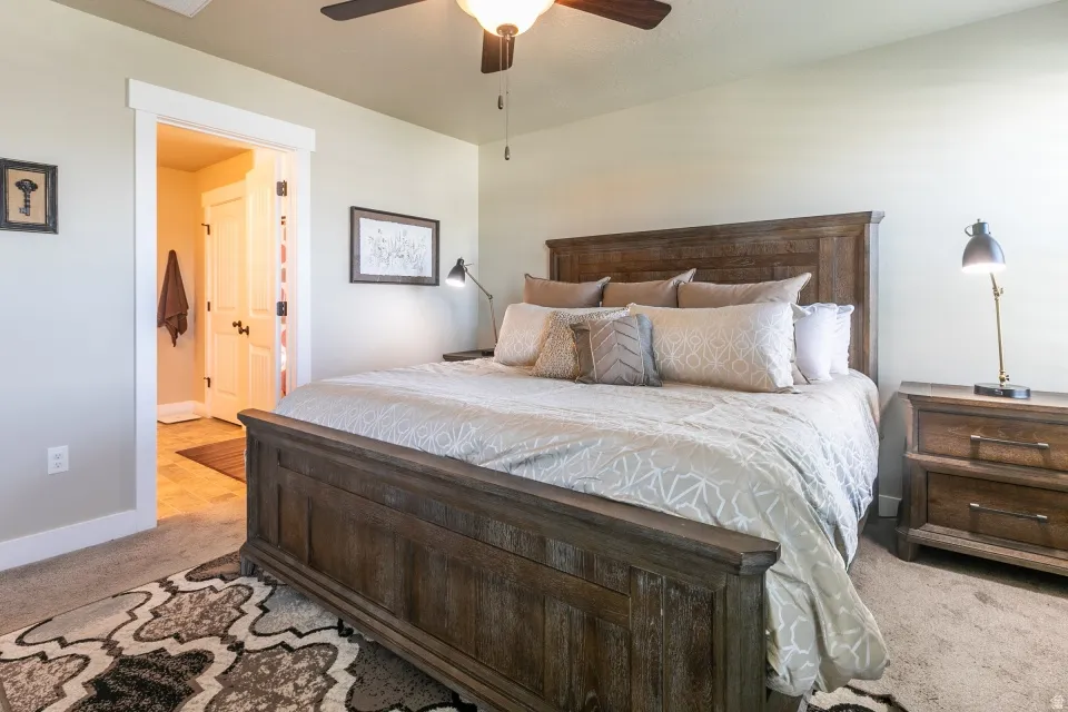 Carpeted bedroom with a ceiling fan, a recessed light, and a wood-finish bed frame