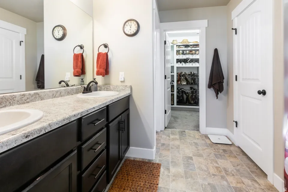Dual sink vanity with dark wood-finish cabinetry, light-toned countertop, and undermount sinks