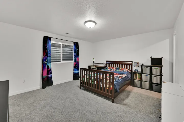 Bright room with white painted walls, gray carpeting, and a single window