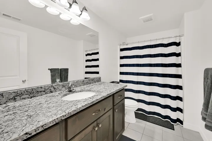 Vanity with an integrated sink, granite-style countertop, and wood-finish cabinetry