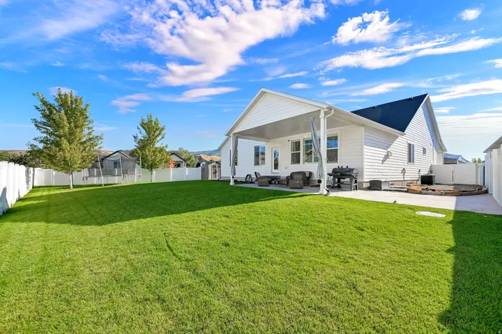 Expansive grass lawn with a white privacy fence
