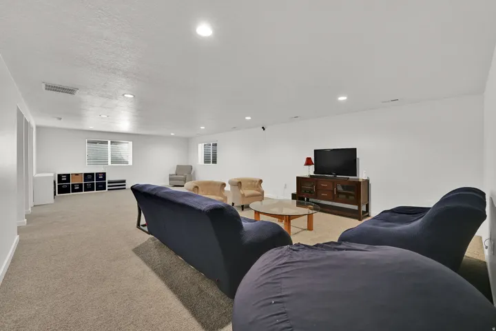 Spacious room with recessed lighting, light-toned carpeting, and multiple windows