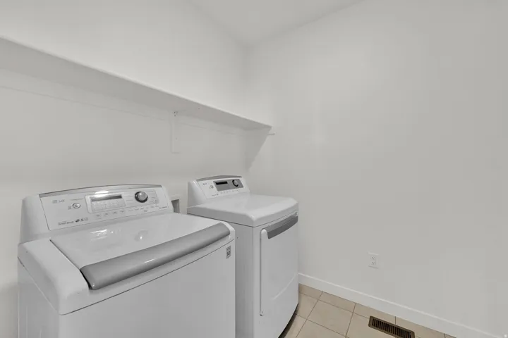 Laundry area featuring tile flooring and an overhead storage shelf