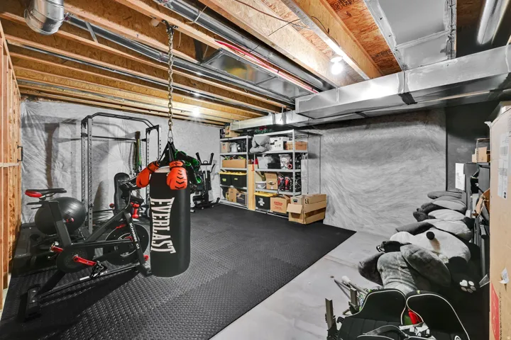 Exposed wood ceiling joists and ductwork, with a dedicated area of rubber flooring