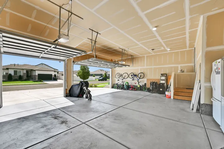 Spacious two-car garage with concrete flooring and multiple overhead garage doors