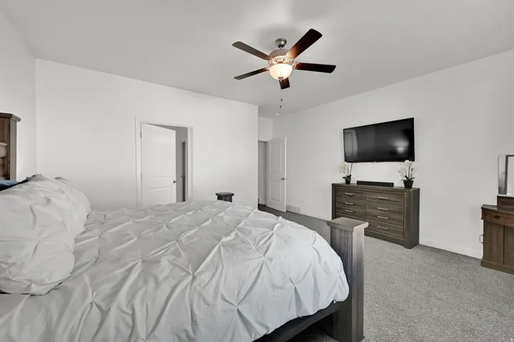Recessed lighting, ceiling fan with integrated lighting, neutral wall tones, and gray carpeting