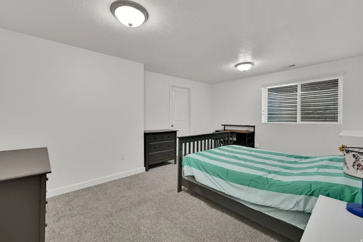 Neutral wall color, wall-to-wall carpeting, recessed ceiling lighting, single window with blinds, and white trim