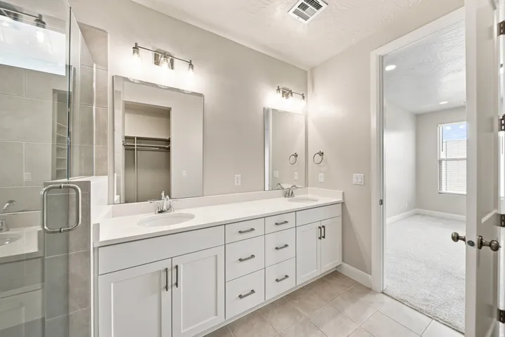 Dual vanity with white cabinetry, quartz countertops, and undermount sinks