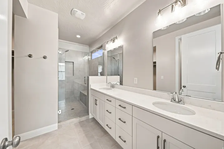 Dual vanity with white cabinetry, sleek countertops, and undermount sinks