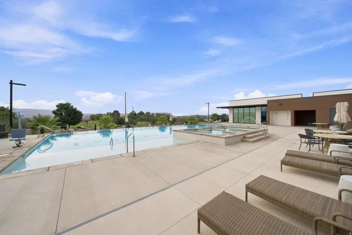 Resort-style pool with integrated spas, expansive concrete decking, and a modern clubhouse structure