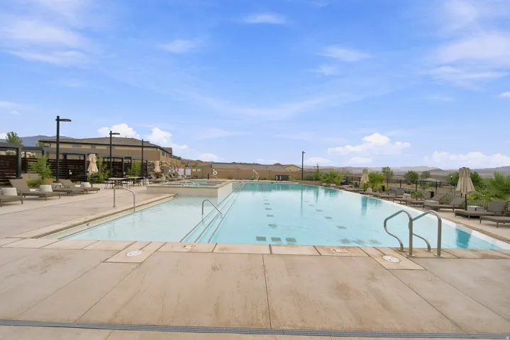Expansive community pool with integrated spa, concrete decking, and designated shallow area