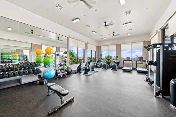 Fitness center featuring large windows, ceiling fans, recessed lighting, and a rubberized floor