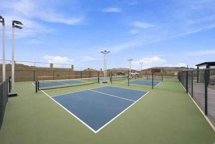 Multiple pickleball courts with painted surfaces, permanent nets, and perimeter fencing