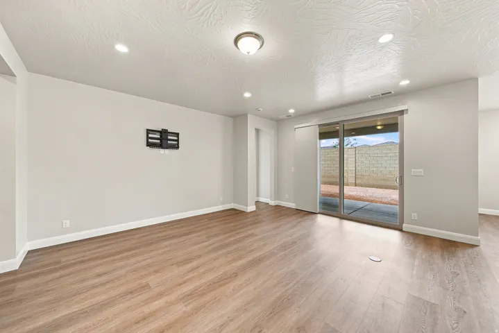 Wood-finish flooring throughout, recessed lighting, and a sliding glass door