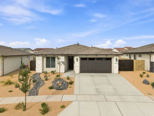Contemporary stucco exterior with stone accents, an attached garage, a concrete driveway, and low-maintenance landscaping