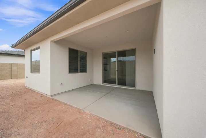 Covered patio with a concrete surface, stucco exterior, and sliding glass door