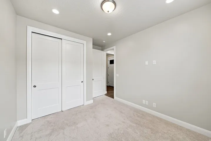 Soft neutral wall finishes, recessed lighting, and a semi-flush mount light fixture