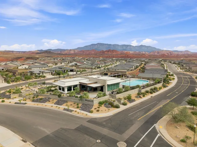 Modern community building with a swimming pool, surrounded by residential properties and desert landscaping