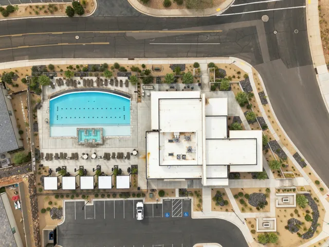 Expansive outdoor pool with integrated spa and surrounding lounge seating, featuring private cabanas and a dedicated parking area