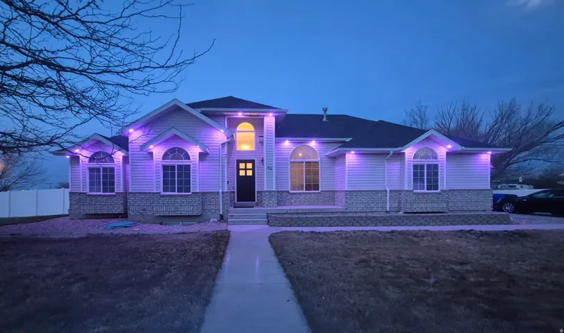 Siding exterior with stone veneer accents, arched windows, and a prominent entry
