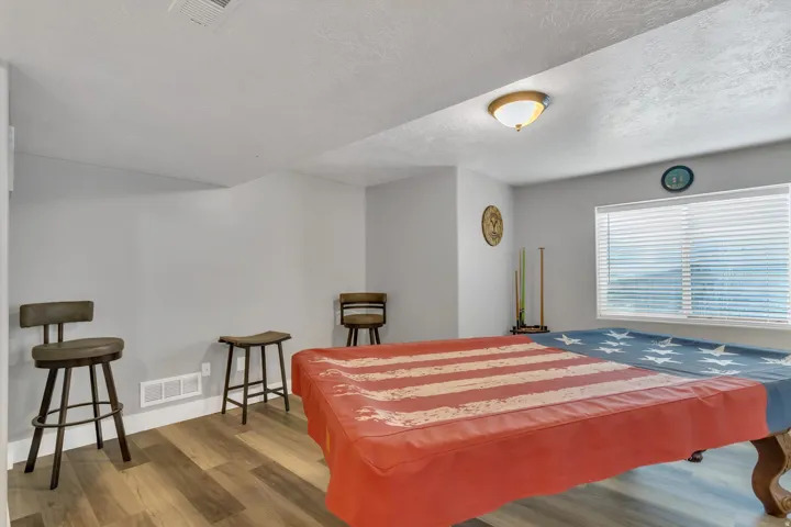 Recessed lighting fixture, light wood-finish flooring, white window blinds, and light gray wall paint