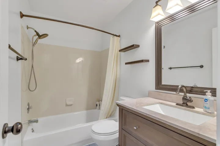 White bathtub and shower combination with a handheld showerhead