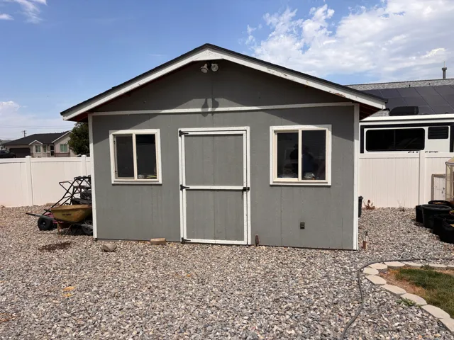 Detached shed with two windows, a single entry door, and a pitched roof