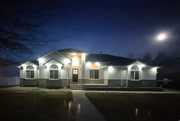 White siding exterior with a dark roof and stone veneer accents