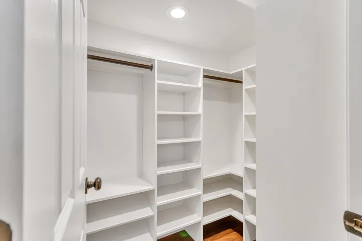 Custom built-in shelving, integrated hanging rods, and recessed lighting