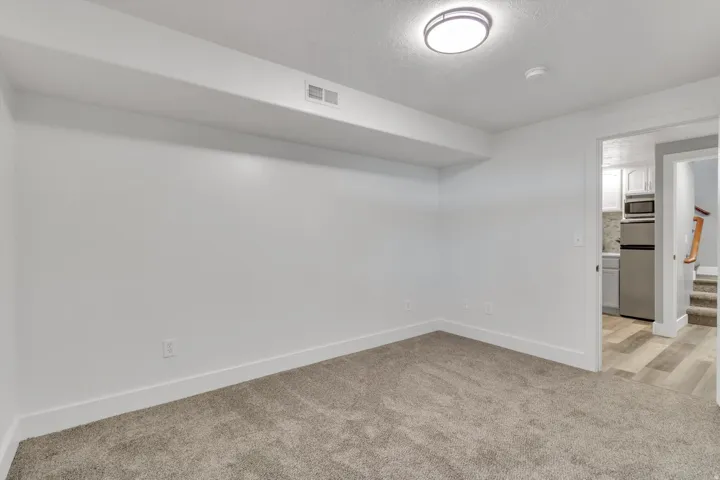 Carpeted room with recessed lighting and a neutral color palette