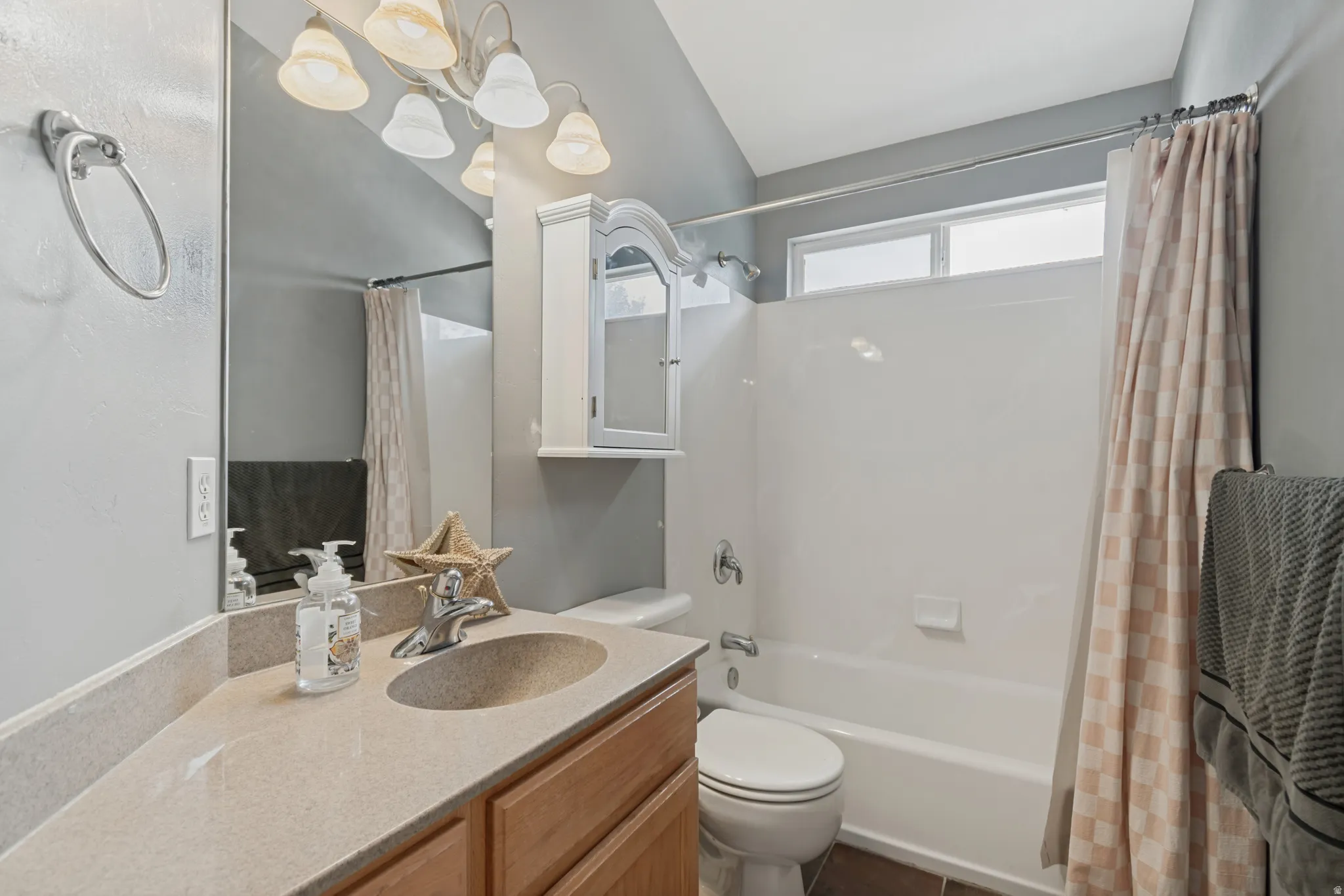 Spa-inspired bathroom featuring a wood-finish vanity with a round vessel sink, quartz countertop, and chrome fixtures